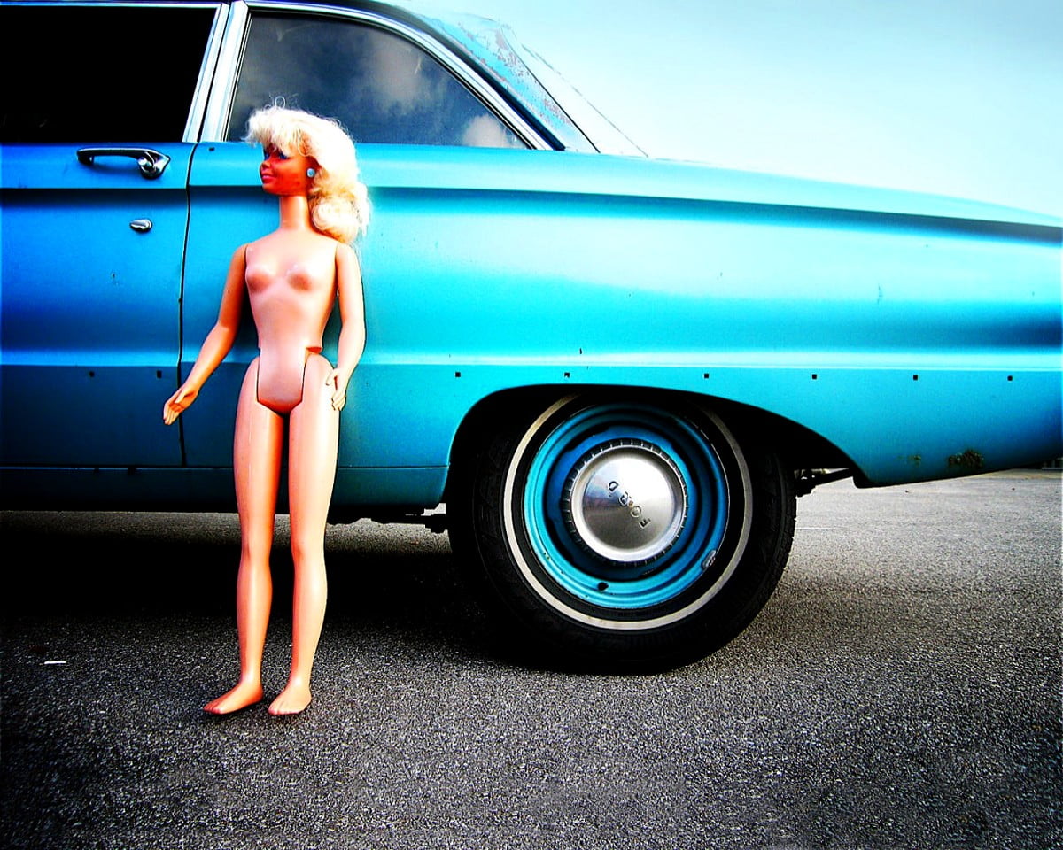 Osoba stojąca przed niebieskim samochodem
